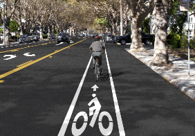person cycling in brightly painted bike lane